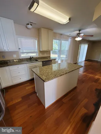a kitchen with a sink cabinets and wooden floor