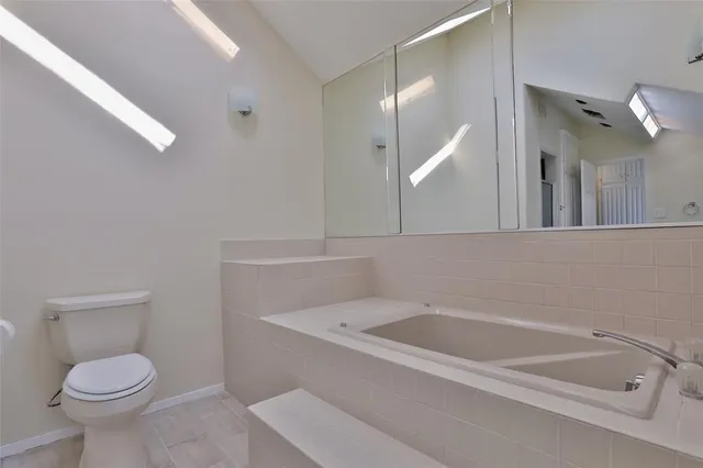 a bathroom with a granite countertop toilet and a sink