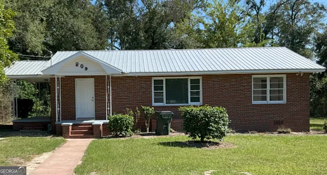 a front view of a house with a yard and outdoor seating