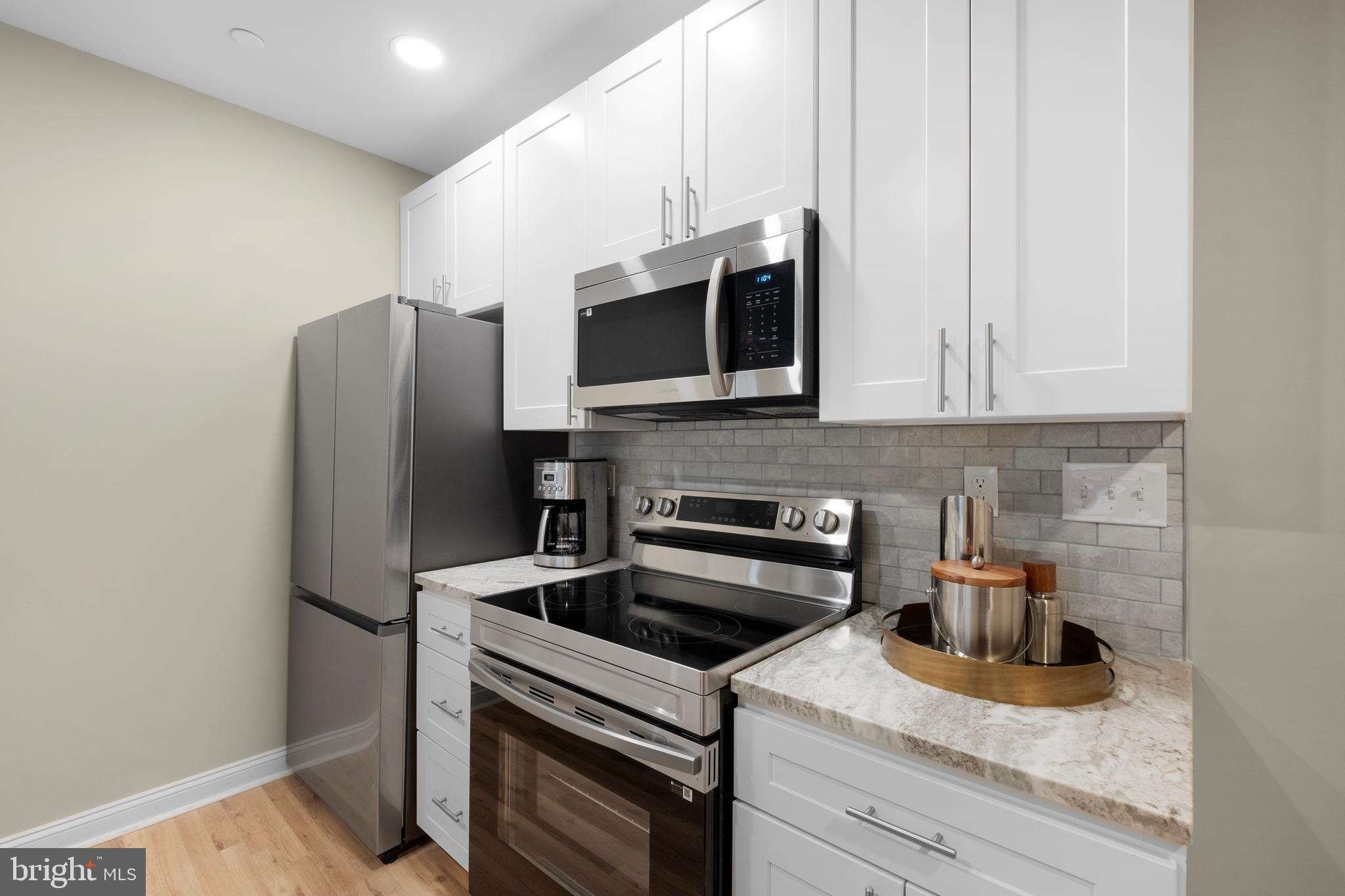 1420-22 Chestnut Street, Unit 604 Philadelphia, PA 19102 - Photo 15 of 35 a kitchen with stainless steel appliances granite countertop a refrigerator stove and sink