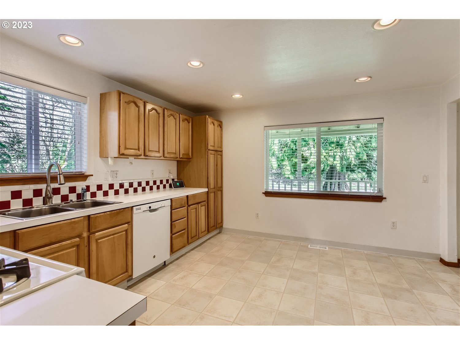 5585 Southwest River Road Hillsboro, OR 97123 - Photo 15 of 29 a kitchen with stainless steel appliances kitchen island granite countertop a stove a sink and a refrigerator