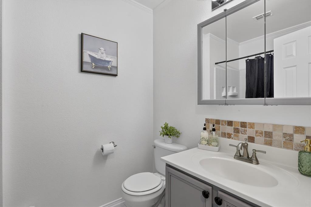 12933 Azure Heights Place Rhome, TX 76078 - Photo 18 of 37 Vanity with integrated sink, mosaic tile backsplash, medicine cabinet, and toilet
