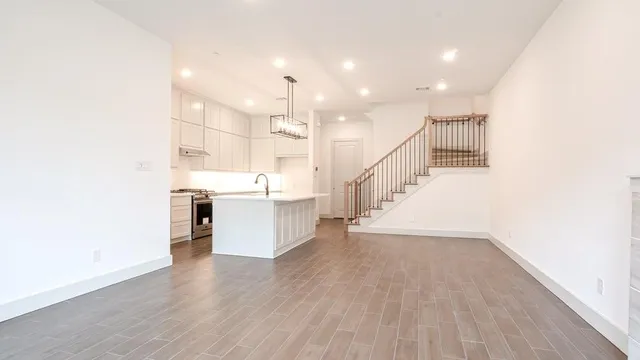 a view of a kitchen with wooden floor and electronic appliances