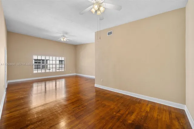 a view of an empty room with wooden floor