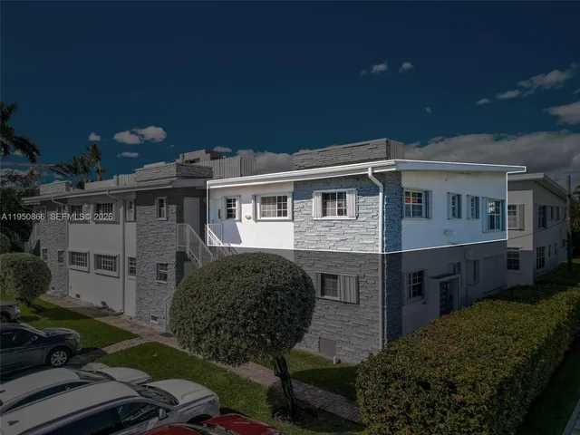 an aerial view of a city with lots of residential buildings ocean and mountain view in back