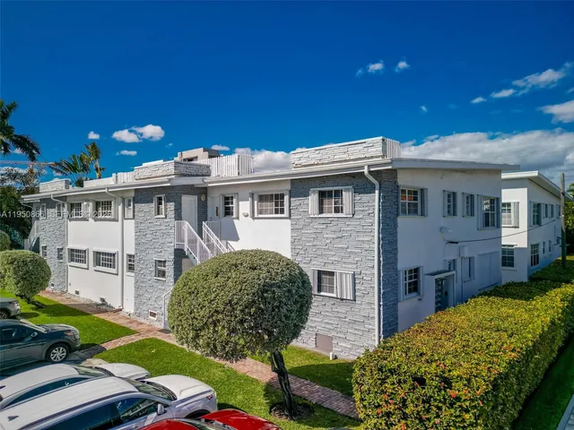an aerial view of a city with lots of residential buildings ocean and mountain view in back
