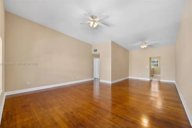 a view of an empty room with wooden floor