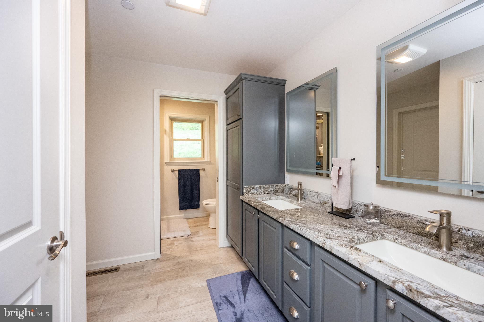 1488 Marsh Hill Road McHenry, MD 21541 - Photo 27 of 64 a bathroom with double vanity sinks a vanity and a large mirror
