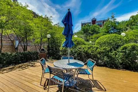 a room with stainless steel appliances lots of furniture and wooden floors