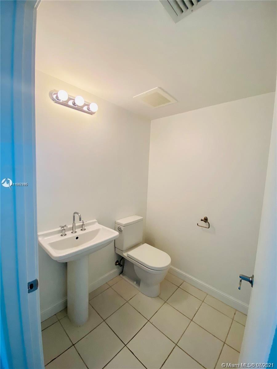 185 Southwest 7th Street, Unit 3502 Miami, FL 33130 - Photo 13 of 15 a bathroom with a sink a toilet and a mirror