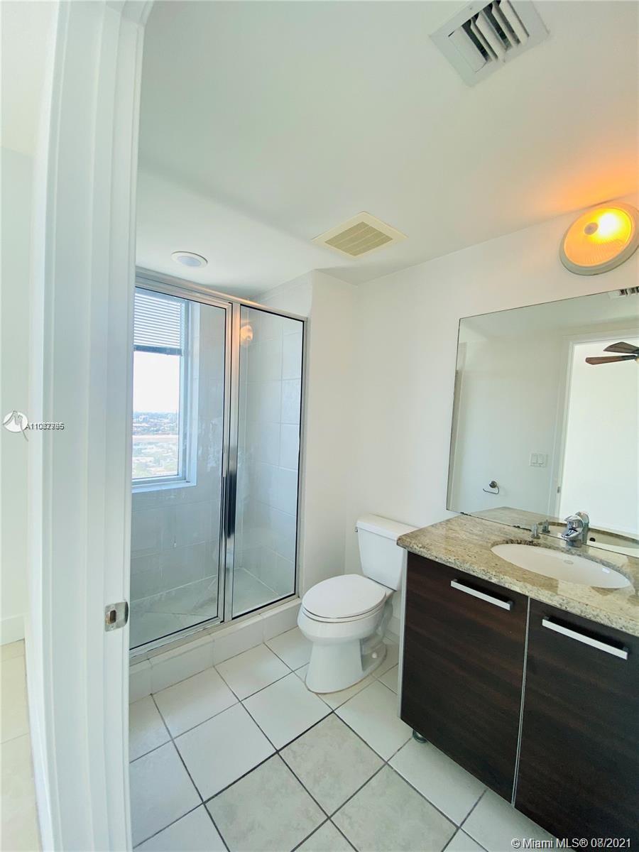 185 Southwest 7th Street, Unit 3502 Miami, FL 33130 - Photo 14 of 15 a bathroom with a granite countertop sink a toilet a mirror and shower