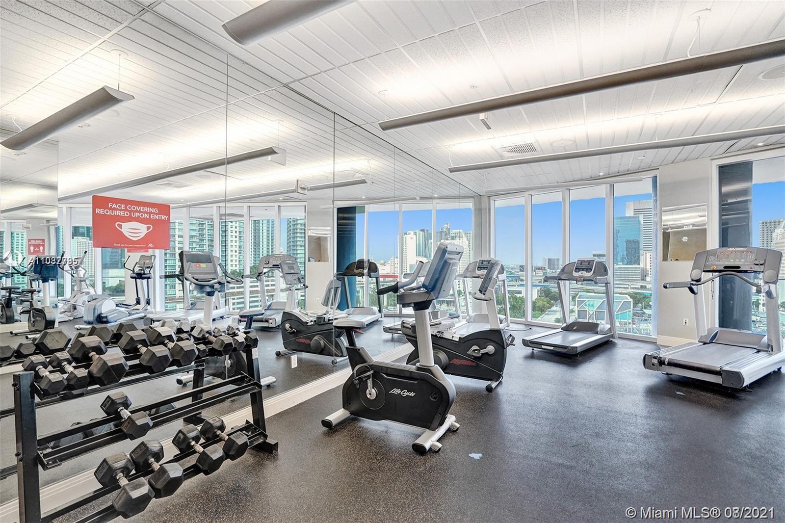185 Southwest 7th Street, Unit 3502 Miami, FL 33130 - Photo 7 of 15 a room with gym equipment and a large window