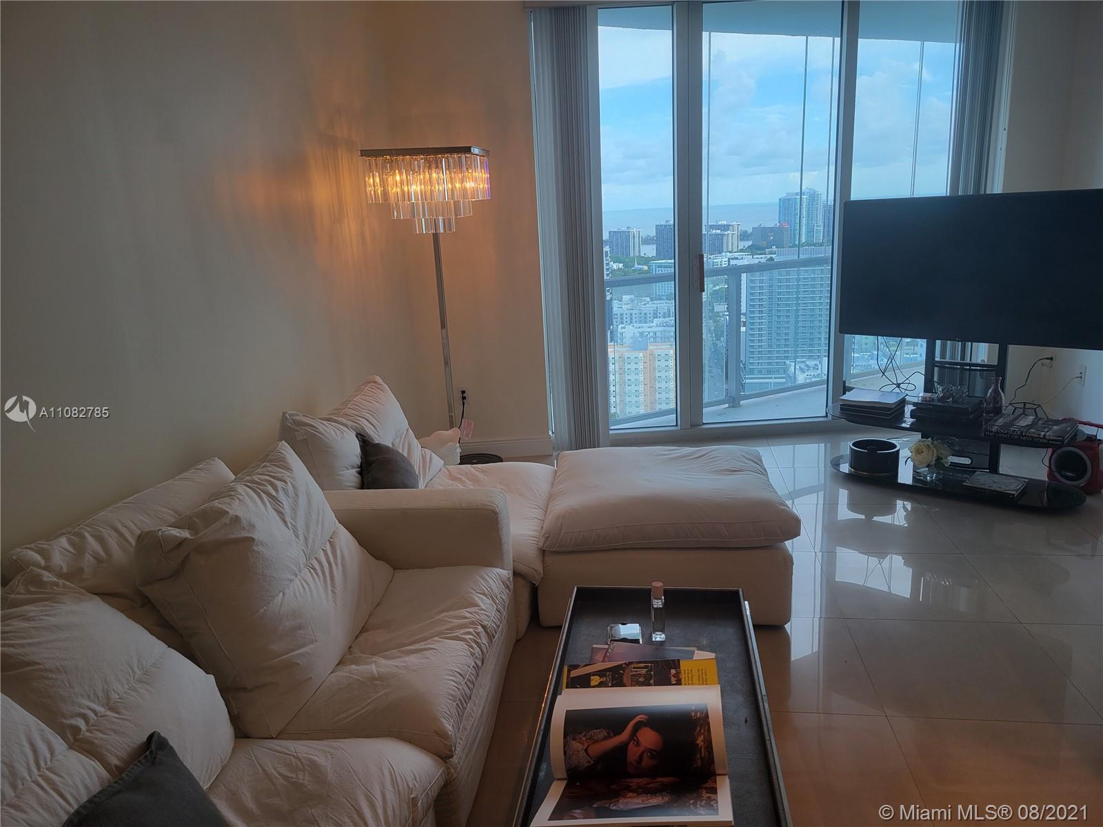 185 Southwest 7th Street, Unit 3502 Miami, FL 33130 - Photo 10 of 15 a living room with furniture and a flat screen tv