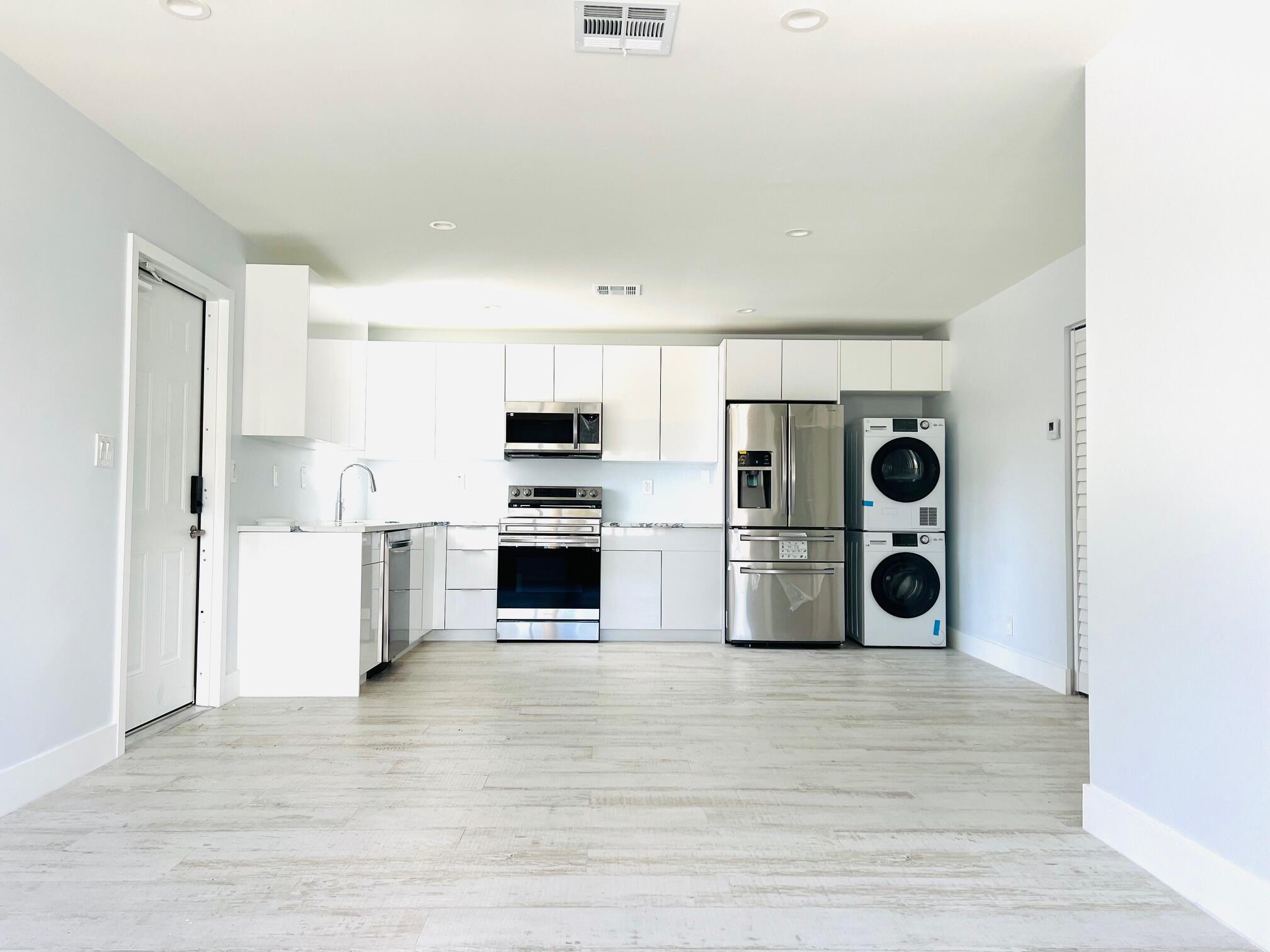 206 Southeast 1st Avenue, Unit 1 Delray Beach, FL 33444 - Photo 2 of 11 a kitchen with stainless steel appliances a refrigerator and a stove top oven