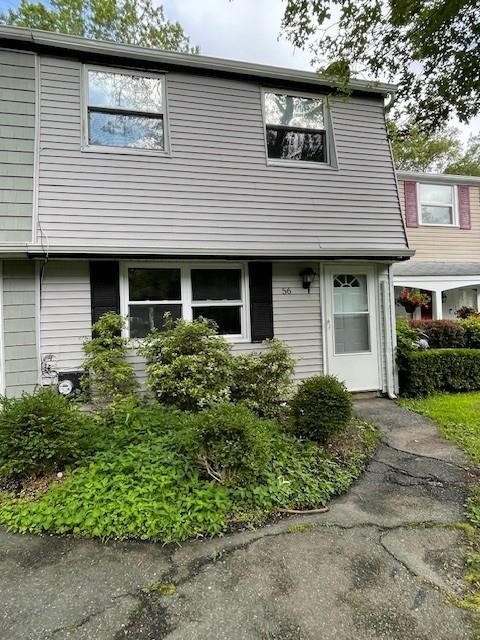 56 Wooded Court Calverton, NY 11933 - Photo 1 of 10 a front view of a house with a garden