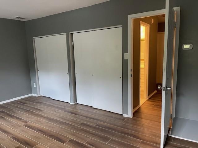 56 Wooded Court Calverton, NY 11933 - Photo 7 of 10 a view of an empty room with wooden floor and a window