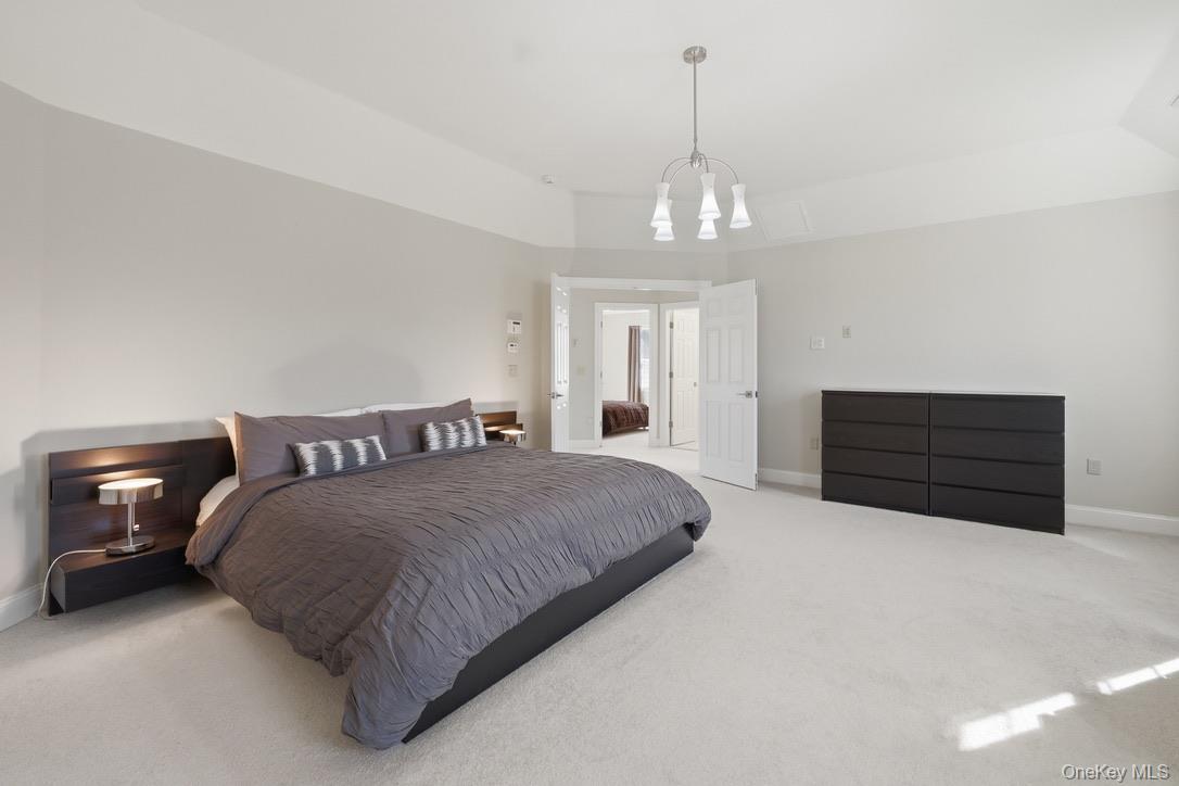 12 Feagles Road Warwick, NY 10990 - Photo 30 of 45 a spacious bedroom with a bed and a chandelier