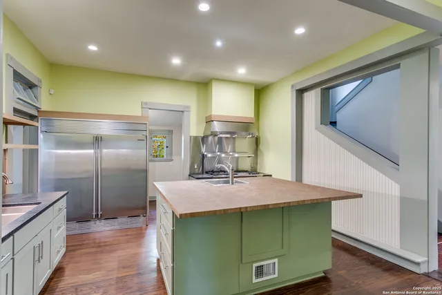 a kitchen with kitchen island a sink stainless steel appliances and cabinets