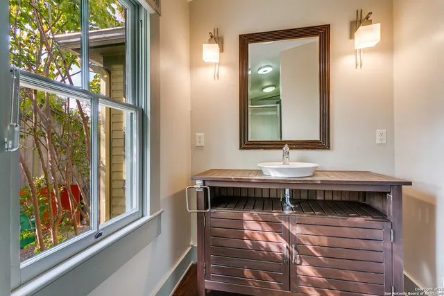 a bathroom with a sink a mirror and a window