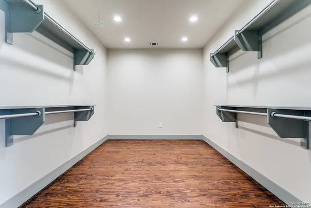 a view of a kitchen with an empty room and wooden floor