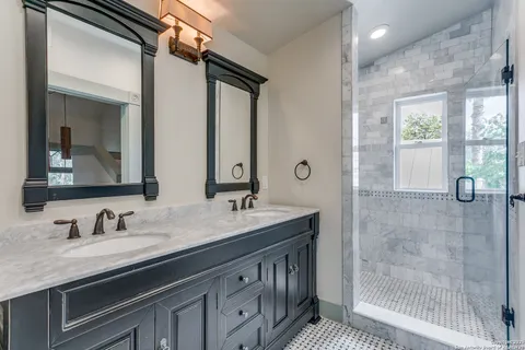a bathroom with double vanity sink and a mirror