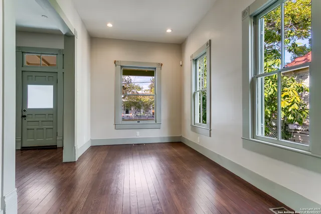 an empty room with wooden floor and a window