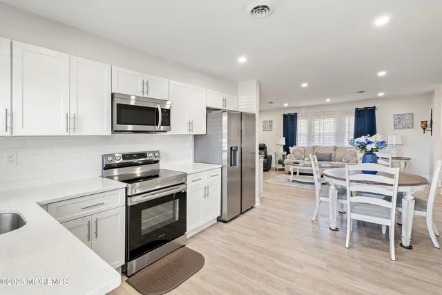 a living room with furniture a flat screen tv and a dining table