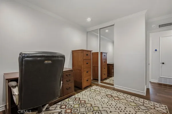 a bedroom with bed and a flat tv screen on a dresser