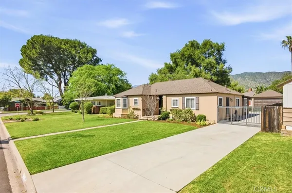 a view of a big house with a big yard and potted plants