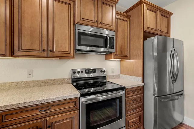 a kitchen with stainless steel appliances granite countertop a refrigerator stove and microwave