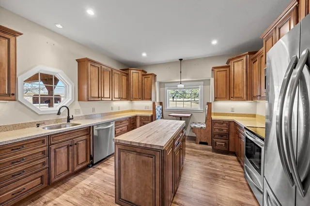 a kitchen with stainless steel appliances granite countertop a sink stove and refrigerator