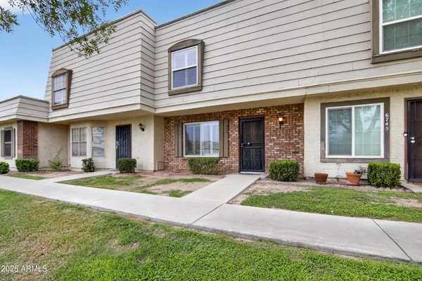front view of a brick house with a yard