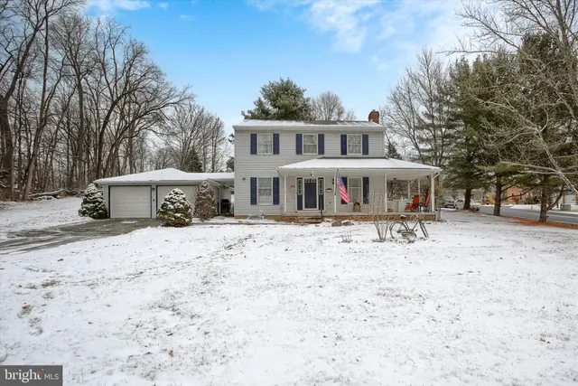 a front view of a house with a yard covered with snow