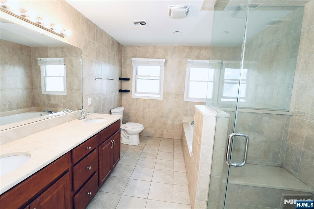 23 Main Avenue Wallington, NJ 07057 - Photo 16 of 29 a spacious bathroom with a double vanity sink a mirror and a shower