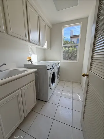 a utility room with dryer washer and a sink