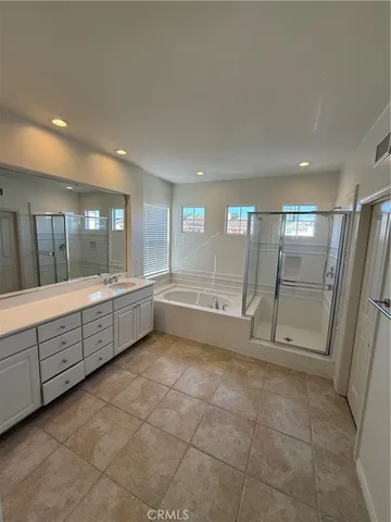 a large bathroom with a glass door shower a sink and a mirror