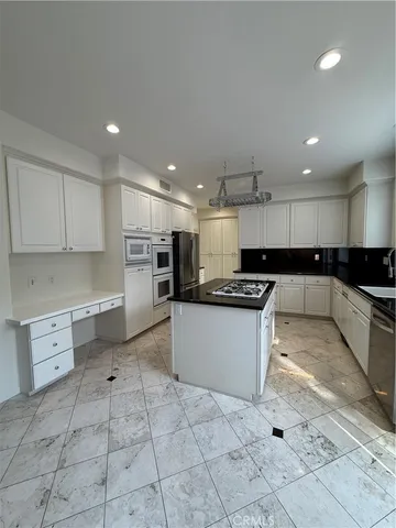 a kitchen with granite countertop a stove top oven a sink and cabinets
