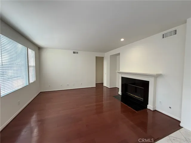 an empty room with windows and fireplace