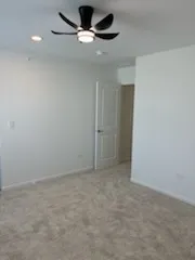 an empty room with a ceiling fan and window