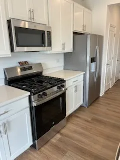 a kitchen with stainless steel appliances granite countertop a stove and a microwave