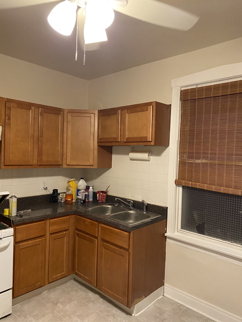 6546 South Rockwell Street, Unit 2 Chicago, IL 60629 - Photo 12 of 25 a kitchen with sink a microwave a stove and cabinets