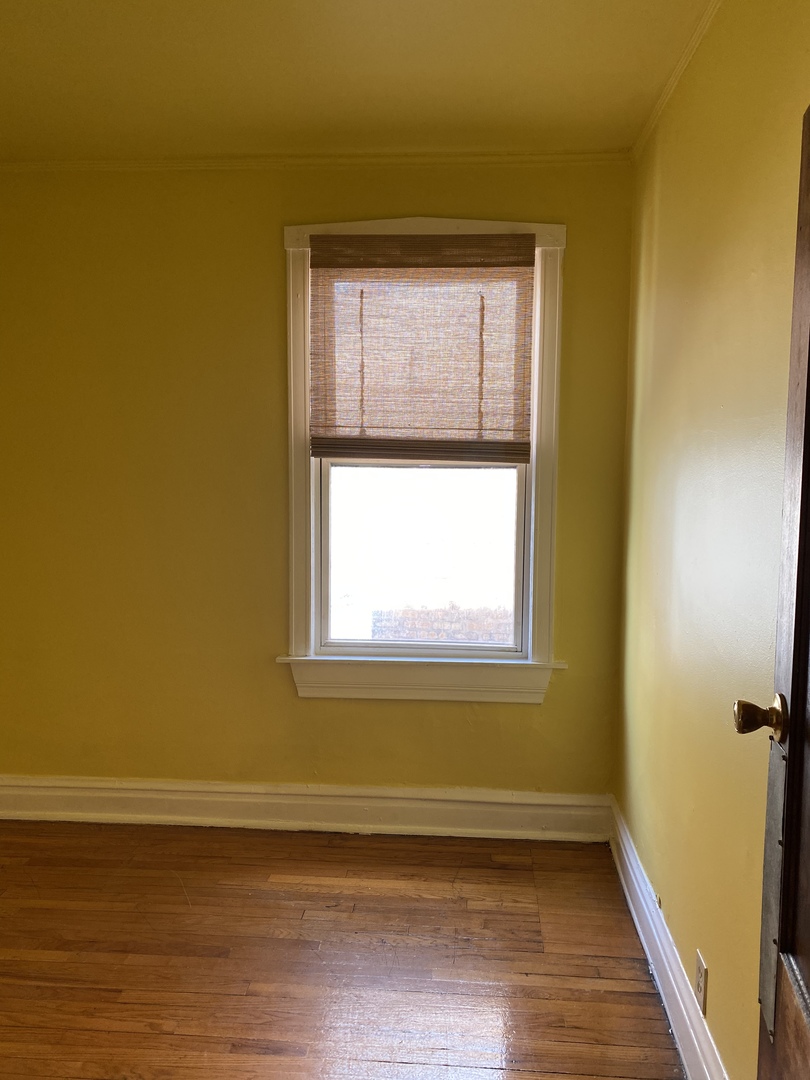 6546 South Rockwell Street, Unit 2 Chicago, IL 60629 - Photo 10 of 25 a view of an empty room with a window and wooden floor