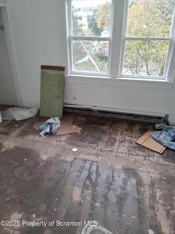 a view of a room with wooden floor and a window