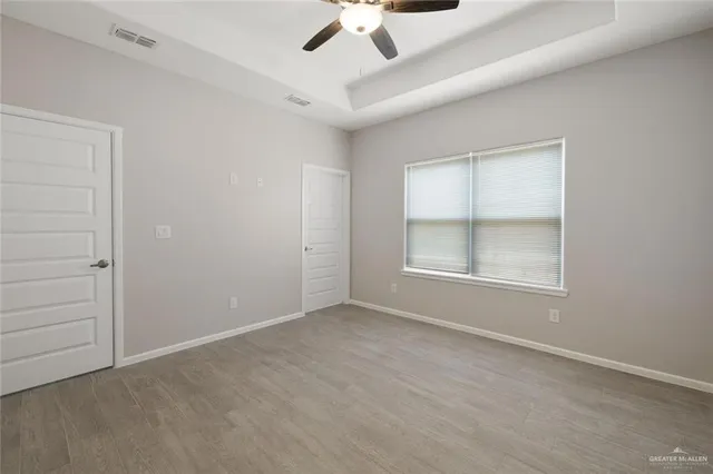 an empty room with a window and a ceiling fan