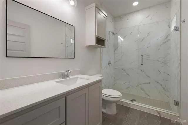 a bathroom with a sink a toilet and shower