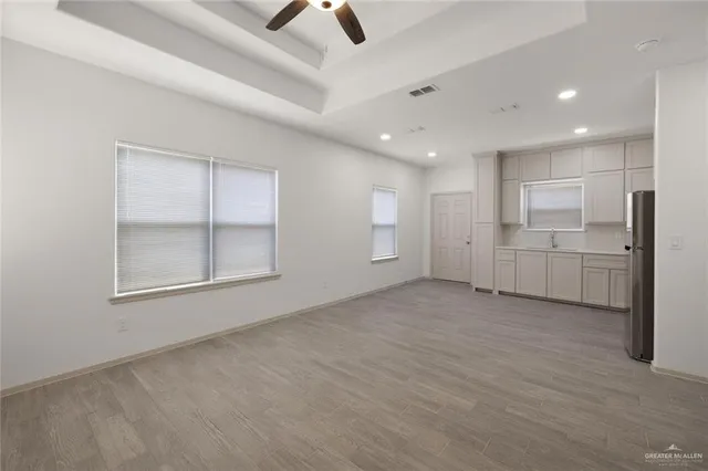 a view of an empty room with window and cabinet