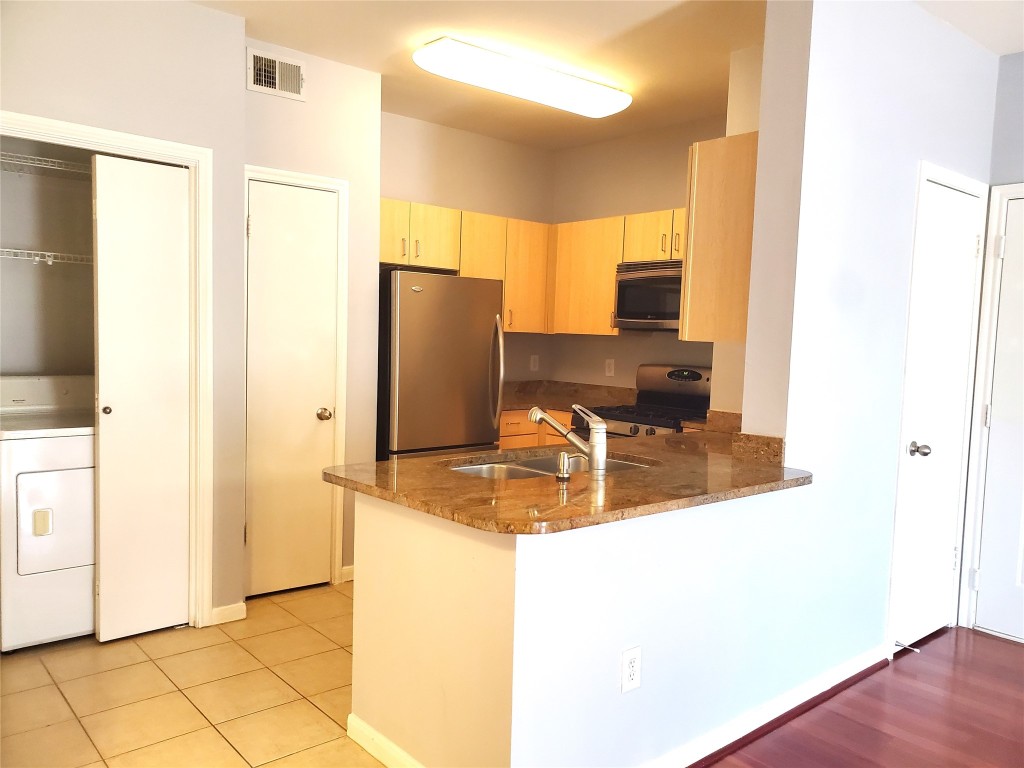 2209 Hancock Drive, Unit 16 Austin, TX 78756 - Photo 7 of 20 a kitchen with stainless steel appliances granite countertop a refrigerator and a sink