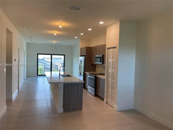 a kitchen with kitchen island stainless steel appliances a sink stove and refrigerator