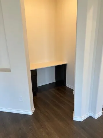 a view of an empty room and wooden floor