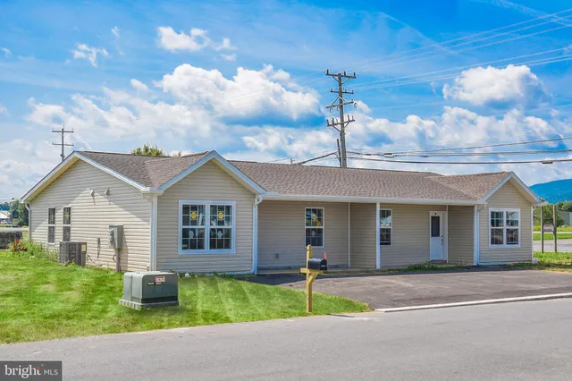 a front view of a house with a garden and plants